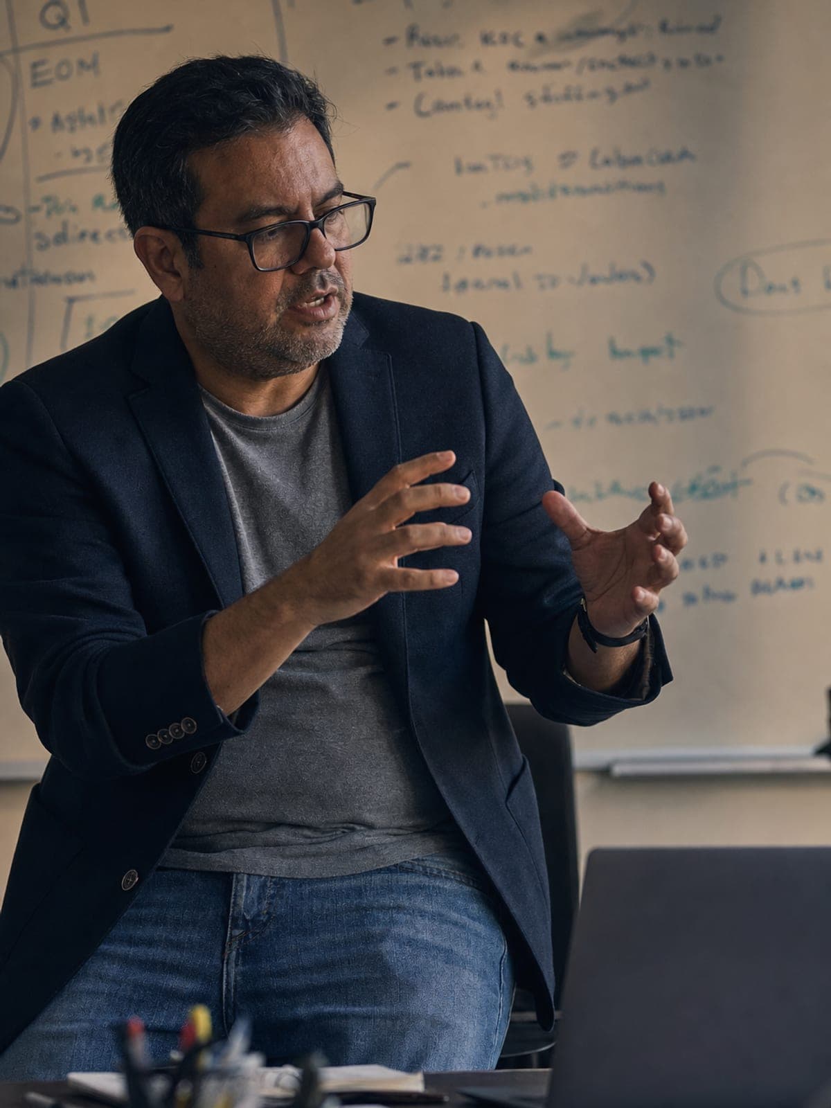 Manager coaching, seated on a desk edge